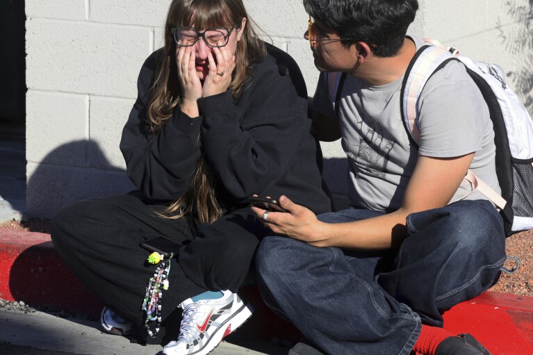 Amanda Perez, left, is comforted by fellow student Alejandro Barrón following a shooting on the campus of the University of Nevada, Las Vegas, Wednesday, Dec. 6, 2023, in Las Vegas.  (KM Cannon/Las Vegas Review-Journal via AP)