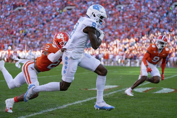 North Carolina wide receiver Devontez Walker (9) catches a pass while covered by Clemson cornerback Nate Wiggins (2) during the first half of an NCAA college football game Saturday, Nov. 18, 2023, in Clemson, S.C. (AP Photo/Jacob Kupferman)