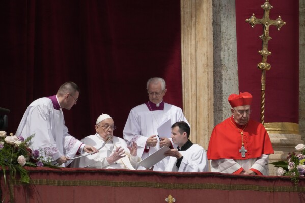 Pope Francis appears on the central lodge of St. Peter's Basilica to bestow the Urbi et Orbi (Latin for to the city and the world) blessing at the end of the Easter mass presided over by Cardinal Angelo Comastri in St. Peter's Square at the Vatican Sunday, April 20, 2025. (AP Photo/Gregorio Borgia)