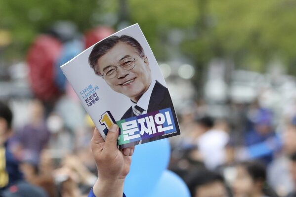 
              FILE - In this Thursday, May 4, 2017 file photo, a supporter of South Korean presidential candidate Moon Jae-in of the Democratic Party holds a leaflet during an election campaign in Goyang, South Korea. Moon, chief of staff for a late liberal president, is forecast to win May 9 presidential election in South Korea. An election victory would be another drama in a life that includes acute post-war poverty, imprisonment for fighting against a dictator and work as a human rights lawyer. (AP Photo/Lee Jin-man, File)
            