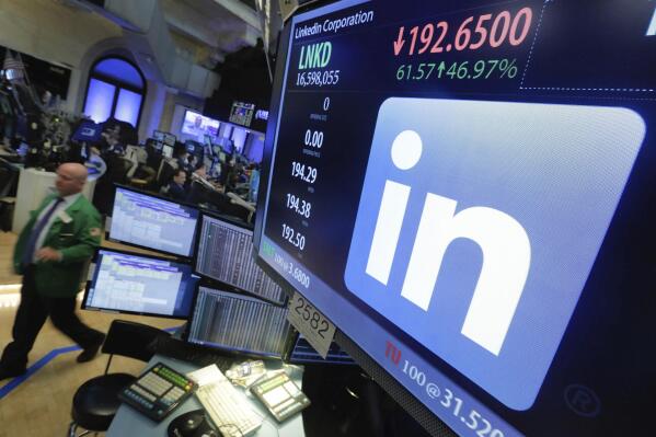 FILE - In this Monday, June 13, 2016, photo, the LinkedIn logo appears on a screen at the post where it trades on the floor of the New York Stock Exchange. The career-networking service LinkedIn has agreed to pay $1.8 million in back wages to hundreds of female workers to settle a pay discrimination complaint brought by U.S. labor investigators. The U.S. Labor Department announced Tuesday, May 3, 2022, that it has reached a settlement agreement with LinkedIn to resolve allegations of “systemic, gender-based pay discrimination” in which women were paid less than men in comparable job roles. (AP Photo/Richard Drew, File)