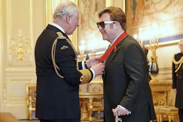 Sir Elton John is made a member of the Order of the Companions of Honour by Prince Charles during an investiture ceremony at Windsor Castle, in Windsor, England, Wednesday, Nov. 10, 2021. (Aaron Chown/PA via AP)