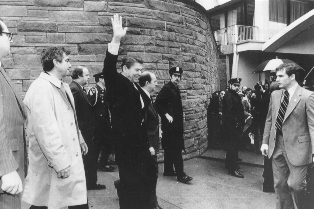 U.S. President Ronald Reagan waves just before he is shot outside the Washington Hilton, Monday, March 30, 1981.  From left are secret service agent Jerry Parr, in raincoat, who pushed Reagan into the limousine; press secretary James Brady, who was seriously wounded; Reagan; Michael Deaver, Reagan's aide; unidentified policeman; Washington policeman Thomas K. Delahanty, who was shot; and secret service agent Timothy J. McCarthy, who was shot in the stomach.  (AP Photo/U.S. White House)