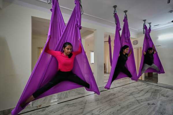 Women at a yoga studio perform an exercise on International Day of Yoga in Hyderabad, India, Saturday, June 21, 2025. (AP Photo/Mahesh Kumar A.)