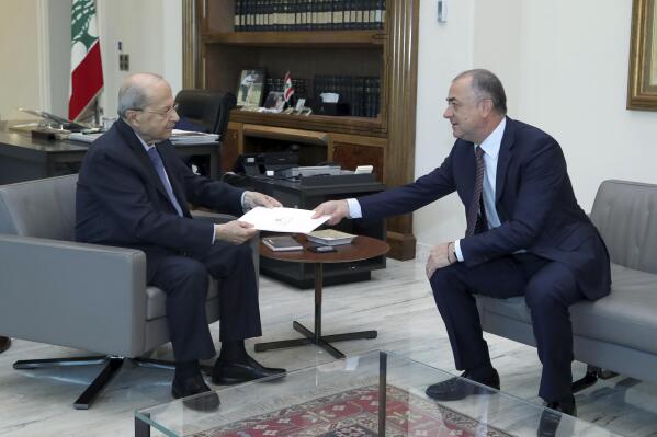 In this photo released by Lebanon's official government photographer Dalati Nohra, Lebanese President Michel Aoun, left, receives the final draft of the maritime border agreement between Lebanon and Israel from the deputy of Lebanese prime minister Elias Bou Saab and who leads the Lebanese negotiations, in Beirut, Lebanon, Tuesday, Oct. 11, 2022. Israel's prime minister said Tuesday that the country has reached an "historic agreement" with neighboring Lebanon over their shared maritime border after months of U.S.-brokered negotiations. (Dalati Nohra via AP)
