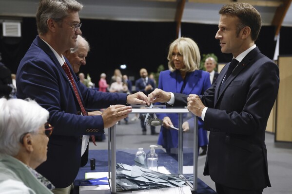 French President Emmanuel Macron, correct, votes for the 2nd spherical of the legislative elections in Le Touque t-Paris-Plage, northern France, Sunday July 7 2024. Vote casting has begun in mainland France on Sunday in pivotal runoff elections that can maybe maybe hand a historic victory to Marine Le Pen's some distance-correct National Rally and its inward-attempting, anti-immigrant vision — or agree with a hung parliament and political impasse. (Mohammed Badra, Pool by the usage of AP)