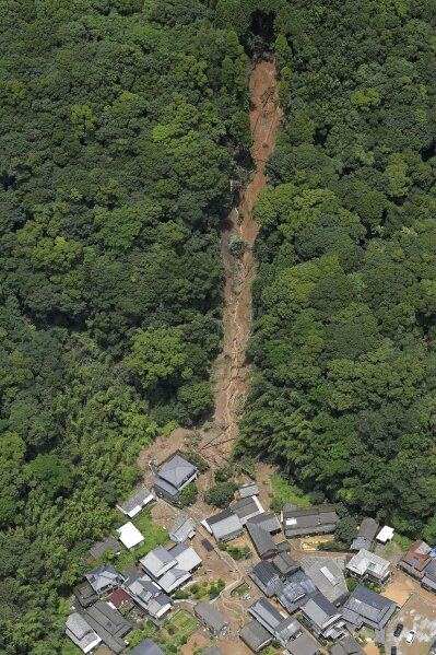 This aerial view shows the site of a mudslide caused by heavy rain in Ashikita town, Kumamoto prefecture, southwestern Japan, Saturday, July 4, 2020. Heavy rain triggered flooding and mudslides on Saturday, leaving more than a dozen missing and others stranded on rooftops waiting to be rescued, officials said. More than 75,000 residents in the prefectures of Kumamoto and Kagoshima were asked to evacuate following pounding rains overnight. (Kyodo News via AP)