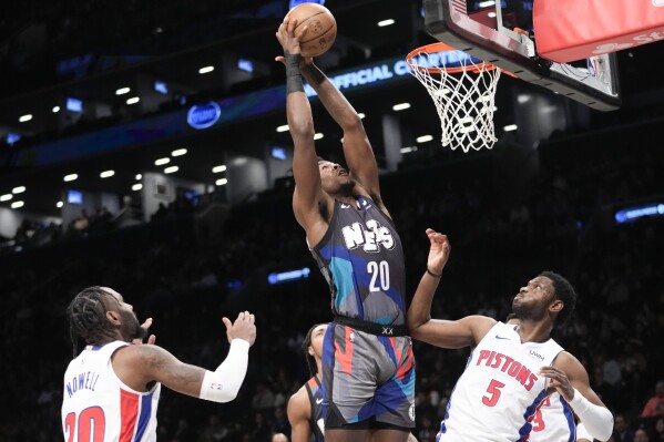 Brooklyn Nets center Day'Ron Sharpe (20) goes to the basket against Detroit Pistons guards Jaylen Nowell (5) and Jaylen Nowell, left, during the first half of an NBA basketball game, Saturday, April 6, 2024, in New York. (AP Photo/Mary Altaffer)