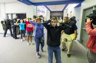 FILE - In this Friday June 9, 2017 file photo, students are led out of school as members of the Fountain Police Department take part in an Active Shooter Response Training exercise at Fountain Midd...