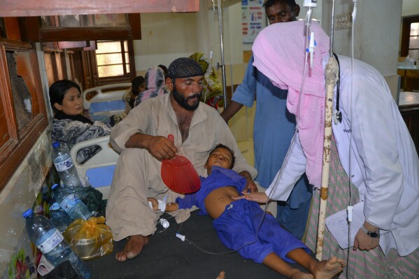 FILE - A doctor checks a child, who is suffering from gastroenteritis due to hot weather, at a hospital in Hyderabad, Pakistan, on May 23, 2024. A new study by the United Nations children’s agency released on Friday May 31, 2024 says developing resilient energy systems to power health facilities in Pakistan could avert over 175,000 deaths by 2030. (AP Photo/Pervez Masih, File)