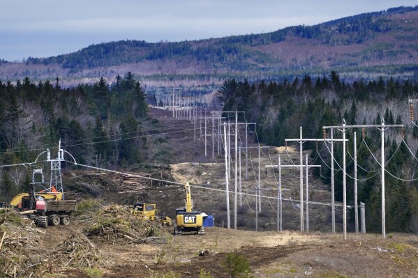 FILE - Heavy machinery is used to cut trees to widen an existing Central Maine Power power line corridor to make way for new utility poles, April 26, 2021, near Bingham, Maine. Construction is resuming on an electricity transmission project that will serve as a conduit for Canadian hydropower to reach the New England power grid despite a half-billion dollar cost increase, with work starting in a week, the head of Avangrid said Thursday, July 27, 2023. (AP Photo/Robert F. Bukaty, File)