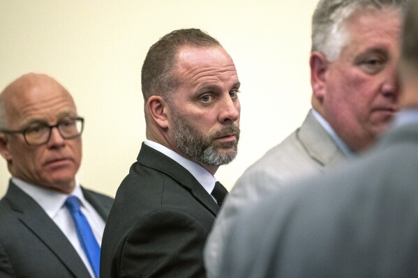 FILE - Former Franklin County Sheriff's Office deputy Jason Meade, center, stands with two of his defense attorneys, Steve Nolder, left, and Mark Collins, Jan. 31, 2024, in Columbus, Ohio. On Friday, May 31, prosecutors asked a judge to dismiss one of two murder counts brought against Meade, a former Ohio sheriff’s deputy who will soon face a retrial in the killing of a 23-year-old Black man. (Brooke LaValley/The Columbus Dispatch via AP, File)