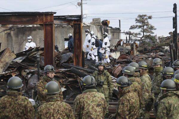 Japanese Self Defense Force members search the collapsed houses in Wajima, Ishikawa prefecture, Japan Thursday, Jan. 11, 2024. A powerful earthquake slammed the western coastline of Japan on New Year’s Day. (Kyodo News via AP)