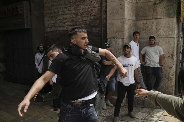 Israeli police push a Palestinian man inside Jerusalem's Old City after he was harassed by Israelis while they are marking Jerusalem Day, an Israeli holiday celebrating the capture of east Jerusalem in the 1967 Mideast war, Monday, May 26, 2025. (AP Photo/Leo Correa)