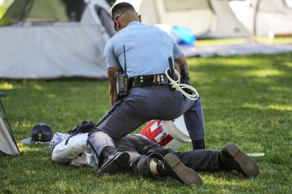 A Georgia State Patrol officer detains a protester on the Emory University campus during a pro-Palestinian demonstration on Thursday, April 25, 2024, in Atlanta.  (AP Photo/Mike Stewart)