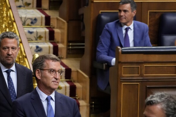 FILE - Conservative Popular Party leader Alberto Núñez Feijoo walks past acting Prime Minister Pedro Sánchez, right, before the start of a voting session at the Spanish parliament in Madrid, Spain, on Aug. 17, 2023. King Felipe VI began consultations with leaders of Spain's political parties Monday Aug. 21, 2023 to see which one has the best chance to form a government following an inconclusive national election last month. (AP Photo/Paul White, File)