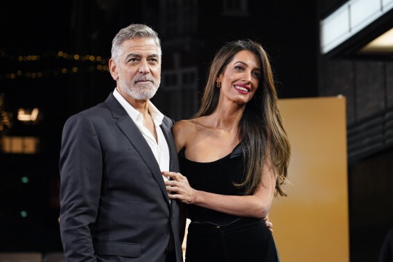 FILE - George Clooney and his wife Amal Clooney pose for photographers upon arrival at the screening of the film The Boys In The Boat, Sunday, Dec. 3, 2023, in London. The Clooney Foundation for Justice, established by human rights lawyer Amal Clooney and Oscar-winning actor and filmmaker George Clooney, announced a new leadership team Tuesday, Jan. 9, 2024, that the Clooneys say will lead the global legal services nonprofit through its “next chapter of growth.”(Photo by Alberto Pezzali/Invision/AP, File)