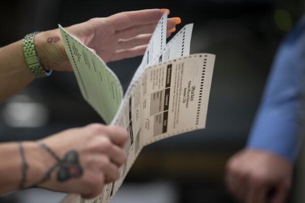 FILE - Poll workers sort out early and absentee ballots at the Kenosha Municipal building on Election Day in Kenosha, Wis., on Nov. 3, 2020. A Wisconsin judge on Wednesday, Sept. 7, 2022,  ordered election clerks not to fill in missing information on witness certification envelopes that contain absentee ballots, delivering a victory to Republicans nine weeks before the election in the battleground state. (AP Photo/Wong Maye-E, File)