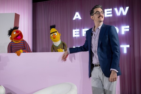 Sal Perez, executive producer and VP of Sesame Street at Sesame Workshop, talks to Bert and Ernie after winning the Elevate Prize Foundation's Catalyst Award, Wednesday, May 14, 2025, in Miami Beach, Fla. (AP Photo/Michael Laughlin)