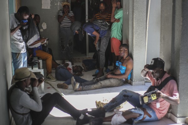 Journalists sit wounded after being shot by armed gangs at the General Hospital in Port-au-Prince, Haiti, Tuesday, Dec. 24, 2024. (AP Photo/Jean Feguens Regala)