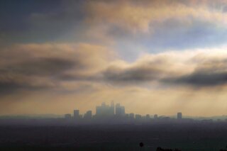 FILE - In this Oct. 26, 2018, file photo, downtown Los Angeles is shrouded in early morning coastal fog and smog. General Motors, Fiat Chrysler, Toyota and many others in the auto industry are siding with the Trump administration in a lawsuit over whether California has the right to set its own greenhouse gas emissions and fuel economy standards. (AP Photo/Richard Vogel, File)
