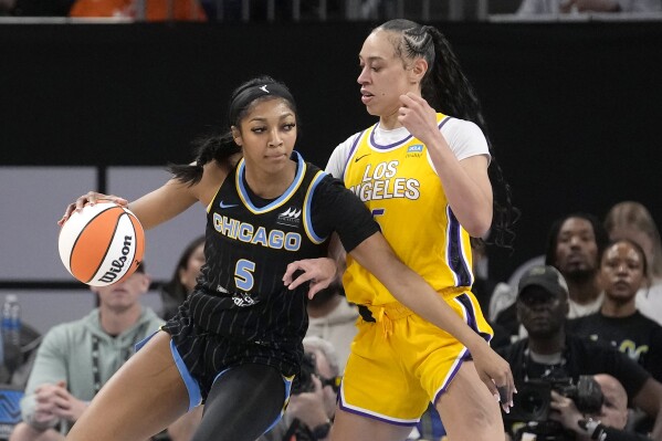 FILE - Chicago Sky's Angel Reese (5) drives to the basket as Los Angeles Sparks' Dearica Hamby defends during the first half of a WNBA basketball game, May 30, 2024, in Chicago. Caitlin Clark and Angel Reese will once again step into the spotlight during All-Star Weekend with their matchup against Team USA. (AP Photo/Charles Rex Arbogast, File)