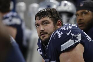 FILE - In this Dec. 5, 2019, file photo, Dallas Cowboys' Zack Martin watches from the bench during the second half of an NFL football game against the Chicago Bears in Chicago. The Cowboys are expected to open the season at Super Bowl champion Tampa Bay without right guard Martin after the four-time All-Pro tested positive for COVID-19. (AP Photo/Charles Rex Arbogast, File)