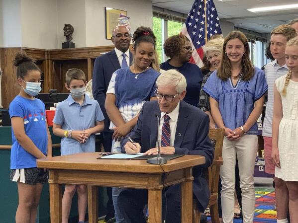 Democratic Wisconsin Gov. Tony Evers signs the Republican-written state budget that includes a $2 billion income tax cut at Cumberland Elementary School, Thursday, July 8, 2021, in Whitefish Bay, Wis. (AP Photo/Scott Bauer)