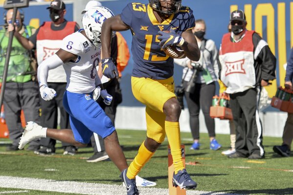 West Virginia wide receiver Sam James (13) scores a touchdown against Kansas during an NCAA college football game, Saturday, Oct. 17, 2020, in Morgantown, W.Va. (William Wotring/The Dominion-Post via AP)