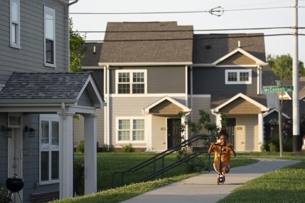 Tay Tay Washington rides a scooter in the Five Points neighborhood Friday, Aug. 4, 2023 in Knoxville, Tenn. (AP Photo/George Walker IV)