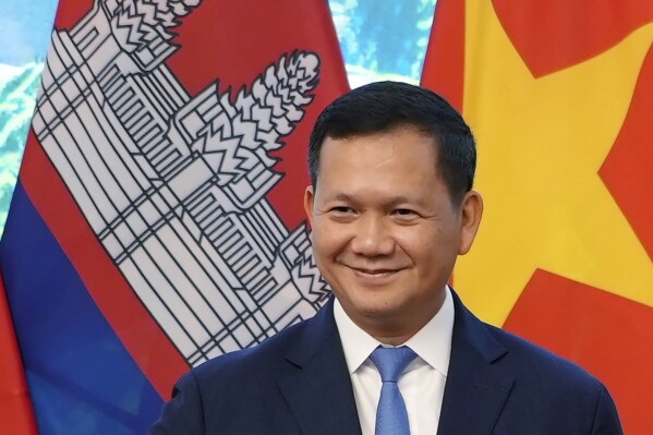 FILE - Cambodian Prime Minister Hun Manet poses for photo, along with Vietnamese Prime Minister Pham Minh Chinh, not in photo, in Hanoi, Vietnam Dec. 11, 2023. Prime Minister Hun Manet arrived Wednesday, Feb. 7, 2024, in Thailand’s capital on his first official visit since becoming his country’s leader last year, seeking to renew the close ties the two countries have maintained in recent times.(AP Photo/Hau Dinh, File)