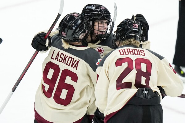 Montreal's Marie-Philip Poulin, center, celebrates with teammates Montreal's Dominika Laskova, left, and Catherine Dubois, right, after scoring an empty-net goal during the third period of a PWHL hockey game against New York Wednesday, Jan. 10, 2024, in Elmont, N.Y. Montreal won 5-2. (AP Photo/Frank Franklin II)