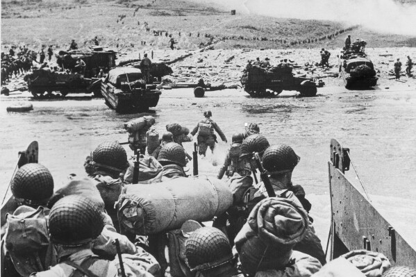 FILE - American soldiers and supplies arrive on the shore of the French coast of German-occupied Normandy during the Allied D-Day invasion on June 6, 1944 in World War II. Nearly 160,000 Allied troops landed in Normandy on June 6, 1944. Of those, 73,000 were from the United States, 83,000 from Britain and Canada. Forces from several other countries were also involved, including French troops fighting with Gen. Charles de Gaulle. The Allies faced around 50,000 German forces. (AP Photo, File)