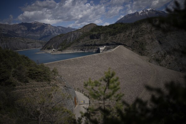 The Serre-Poncon hydroelectric dam is pictured in France, Tuesday, May 2, 2023. Human-caused climate change is lengthening droughts in southern France, meaning the reservoirs are increasingly drained to lower levels to maintain the power generation and water supply needed for nearby towns and cities. (AP Photo/Daniel Cole)