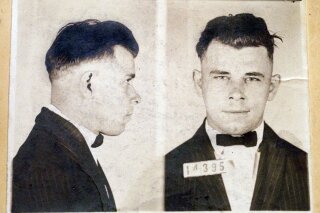 FILE - This file photo shows Indiana Reformatory booking shots of John Dillinger, stored in the state archives, and shows the notorious gangster as a 21-year-old. Records show that Dillinger was admitted into the reformatory on Sept. 16, 1924. The body of the 1930s gangster is set to be exhumed from an Indianapolis cemetery more than 85 years after he was killed by FBI agents. The Indiana State Department of Health approved a permit July 3, 2019, that Dillinger's nephew, Michael C. Thompson, sought to have the body exhumed from Crown Hill Cemetery and reinterred there.(AP Photo/The Indianapolis Star, Charlie Nye, File)