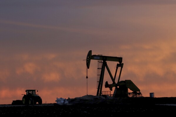 FILE - A well pump works at sunset on a farm near Sweetwater, Texas, on Dec. 22, 2014. Diamondback Energy will buy rival Endeavor Energy Resources in a cash-and-stock deal valued at about $26 billion to create a drilling giant in the Southwest United States. (AP Photo/LM Otero, File)