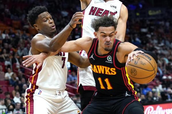 Atlanta Hawks guard Trae Young (11) tires to control the ball as Miami Heat guard Kyle Lowry (7) defends during the first half of an NBA basketball game Friday, April 8, 2022, in Miami. (AP Photo/Lynne Sladky)