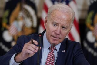 President Joe Biden adjusts his microphone during a meeting with the President's Council of Advisors on Science and Technology in the State Dining Room of the White House, Tuesday, April 4, 2023, in Washington. (AP Photo/Patrick Semansky)
