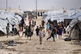 Children gather outside their tents, at al-Hol camp, which houses families of members of the Islamic State group, in Hasakeh province, Syria, Saturday, May 1, 2021.  It has been more than two years that some 27,000 children have been left to languish in al-Hol camp, which houses families of IS members.   Most of them not yet teenagers, they are spending their childhood in a limbo of miserable conditions with no schools, no place to play or develop and seemingly no international interest in resolving their situation.   (AP Photo/Baderkhan Ahmad)
