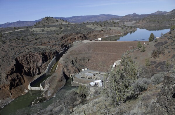 FILE - The Iron Gate Dam powerhouse and spillway are seen on the lower Klamath River near Hornbrook, Calif., on March 2, 2020. This dam, along with three others on the Klamath River, are scheduled to be removed by the end of 2024. Crews will work to restore the river and surrounding land. (AP Photo/Gillian Flaccus, File)