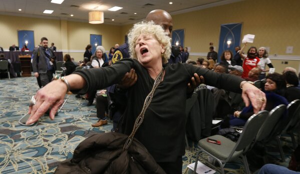 FILE - In this Jan. 8, 2019, file photo, a protester gets escorted out of a meeting of the Virginia State Air Quality Control Board by State Police in Richmond, Va. The U.S. Supreme Court is set to wade into a long-running battle between developers of a 605-mile natural gas pipeline and environmental groups who oppose the pipeline crossing the storied Appalachian Trail. On Monday, Feb. 24, 2020, the high court will hear arguments on a critical permit needed by developers of the Atlantic Coast Pipeline. (AP Photo/Steve Helber, File)