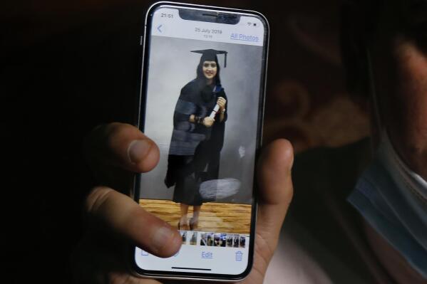 An image of Mayra Zulfiqar, a British woman of Pakistani origin who was found dead at a home, is displayed by her father on his mobile phone during an interview with The Associated Press, in Lahore, Pakistan, Thursday, May 20, 2021. Muhammad Zulfiqar expressed his dissatisfaction over a police probe into the murder of his daughter. He says he is still struggling to get justice for his daughter who was killed when she refused marriage proposals from two men, both Pakistanis. (AP Photo/K.M. Chaudary)