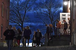 FILE - Students walk out of Johnson Chapel at Amherst College in Amherst, Mass., April 24, 2019. Amherst College will no longer give admissions preference to the children of alumni, the school announced Wednesday, Oct. 20, 2021 ending a practice that has been criticized for giving an additional advantage to students from wealthier families. (AP Photo/Jessica Hill, file)