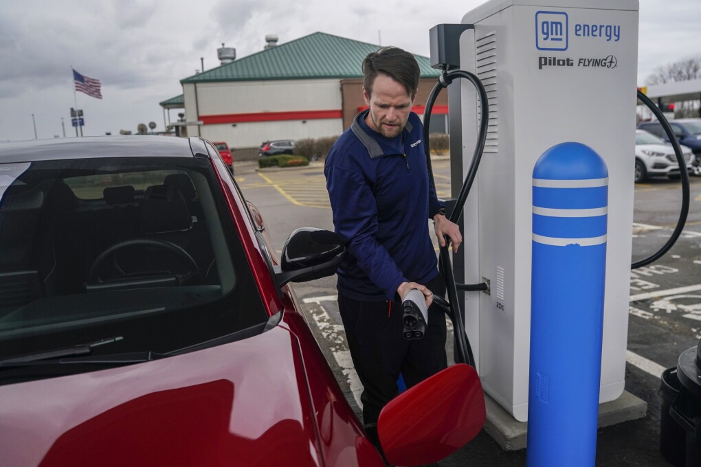 Liam Sawyer, of Indianapolis, charges his 2023 Ford Mustang Mach-E, Friday, March 8, 2024, at an electric vehicle charging station in London, Ohio. The charging ports are a key part of President Joe Biden’s effort to encourage drivers to move away from gasoline-powered cars and trucks that contribute to global warming. (AP Photo/Joshua A. Bickel)