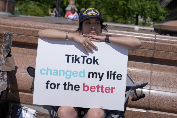 FILE - A TikTok content creator, sits outside the U.S. Capitol, April 23, 2024, in Washington. TikTok is gearing up for a legal fight against a U.S. law that would force the social media platform to break ties with its China-based parent company or face a ban. A battle in the courts will almost certainly be backed by Chinese authorities as the bitter U.S.-China rivalry threatens the future of a wildly popular way for young Americans to connect online. (AP Photo/Mariam Zuhaib, file)
