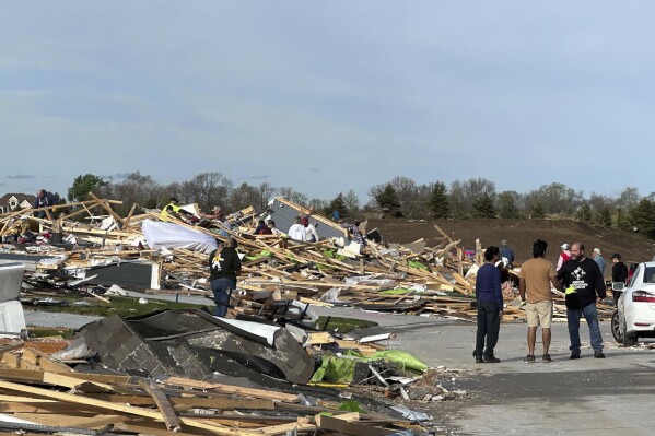 People are pick through the rubble of a house that was leveled in Elkhorn, Neb., on Saturday, April 27, 2024. Residents began sifting through the rubble after a tornado plowed through suburban Omaha, demolishing homes and businesses as it moved for miles through farmland and into subdivisions. (AP Photo/Nicholas Ingram)