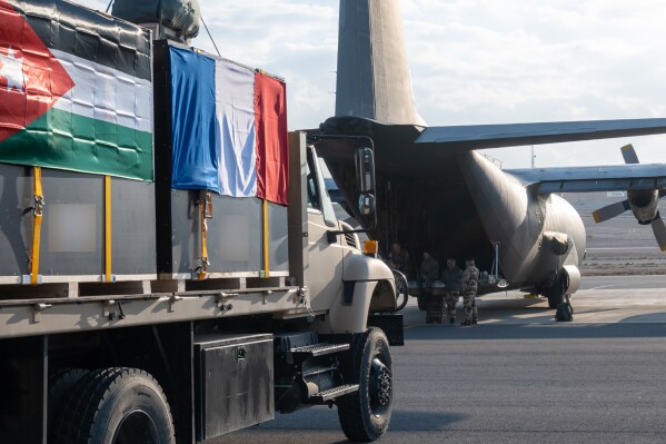 This photo provided by the French Army shows containers being loaded into a C-130 military plane, Thursday, Jan. 4, 2024 on a French military airbase in Jordan. France announced Friday that a French and a Jordanian military transport aircraft air-dropped a total of seven tons of medical aid to a field hospital into the Gaza Strip during a joint operation. The operation is meant to deliver medical aid to the Jordanian field hospital of the southern city of Khan Younis. (Etat Major des Armees via AP)