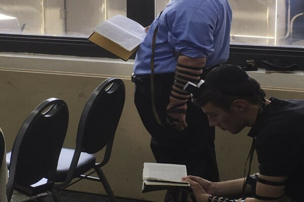 In this Aug. 28, 2017, photo provided by Stephen Glicksman, student Saadya Ehrenpreis, left, participates in morning prayers in Rubin Hall at Yeshiva University in New York. Ehrenpreis died of COVID-19 on April 28, just one month before he would have graduated from the Makor College Experience program at the university. (Stephen Glicksman via AP)