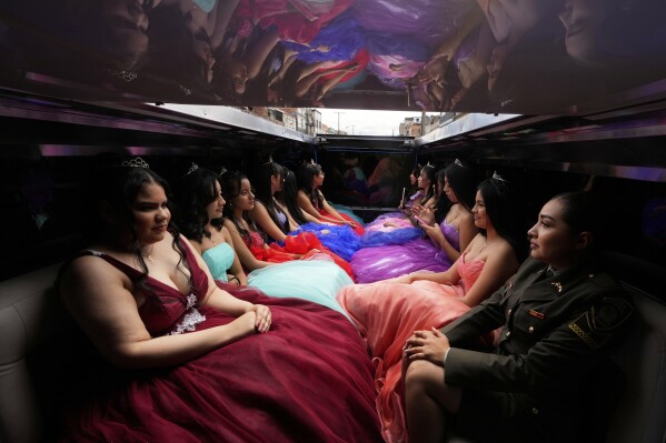 Quinceañeras ride in a limousine as part of their celebration in Bogota, Colombia, May 2, 2025. The Sueños Hechos Foundation, led by a former police officer, is hosting a quinceañera celebration for 24 disadvantaged teen girls. (AP Photo/Fernando Vergara)