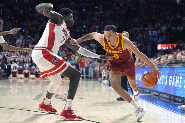 Southern California forward Kobe Johnson (0) drives on Arizona center Oumar Ballo during the first half of an NCAA college basketball game Thursday, Jan. 19, 2023, in Tucson, Ariz. (AP Photo/Rick Scuteri)